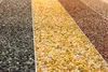 A close-up view of different colored gravel samples arranged in vertical stripes. Produktbild-Vorschau