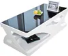 A modern white coffee table with a black glass top, decorated with a small bowl of fruit and a tablet device. Podgląd zdjęcia produktu