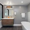 A modern bathroom with a vanity, bathtub, and a wall-mounted heater. Voir les images du produit
