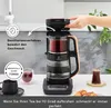 A person is using a tea maker in a kitchen setting, with tea cups and pastries nearby. Produktbild-Vorschau