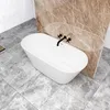 A freestanding oval bathtub in a modern bathroom with marble-like tiles. Produktbild-Vorschau