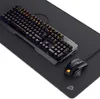 A gaming keyboard, mouse, and mousepad set on a black surface. Produktbild-Vorschau