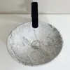 A top-down view of a marble-patterned sink with a black faucet. Náhľad obrázku produktu