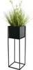 A black metal plant stand with a green potted plant. Produktbild-Vorschau