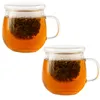 Two glass tea cups with infusers and lids, filled with tea. Náhled obrázku produktu