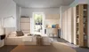 A modern bedroom with a bed, desk, and wardrobe, featuring natural light from an open door. Produktbild-Vorschau