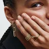A close-up shot of a person's hand and ear, showcasing jewelry. Produktbild-Vorschau
