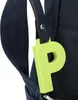 A close-up of a navy blue bag with a lime green 'P' charm attached. Voir les images du produit