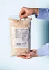 Hands holding a bag of ground almonds. Produktbild-Vorschau