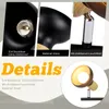Collage of close-up images showing details of a black lamp with wood accents, including the socket, material, and a swiveling light head. Text overlays describe features. Voir les images du produit