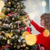 A person is decorating a Christmas tree with ornaments. Náhled obrázku produktu
