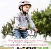 A young boy wearing a pink helmet and gray jacket rides a white balance bike outdoors. Anteprima dell’immagine prodotto