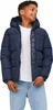 A young boy wearing a navy blue puffer jacket and light blue jeans. Produktbild-Vorschau