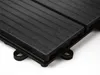 A close-up, angled view of a black WPC interlocking tile, showing its ribbed surface and interlocking mechanism. Náhled obrázku produktu