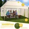 A family is enjoying a meal under a beige pop-up gazebo in a grassy backyard. Anteprima dell’immagine prodotto