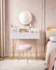 A vanity table with a mirror and various beauty products, next to a bed. Náhled obrázku produktu