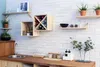 A kitchen or dining area with a wooden countertop, sink, and shelves mounted on a white brick wall. Produktbild-Vorschau