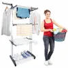 A woman is holding a laundry basket next to a multi-tiered drying rack with clothes on it. Produktbild-Vorschau