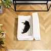 A black cat is lying inside a white insulated cat house on a wooden floor. Náhled obrázku produktu
