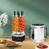 A vertical electric grill with food on it, placed on a table with other food items and a decorative vase. Náhled obrázku produktu