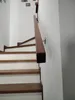 A wooden handrail mounted on a white wall next to a staircase. Náhľad obrázku produktu