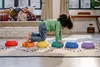 A child is playing on a rug with colorful stepping stones. Voir les images du produit