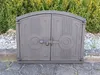 A cast iron oven door is shown in front of a hedge and gravel. Náhľad obrázku produktu