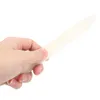 A hand holding a white bone folder tool against a white background. Produktbild-Vorschau