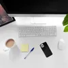 A desk setup with a computer, keyboard, mouse, coffee mug, pen, sticky note, and a smartphone. Produktbild-Vorschau
