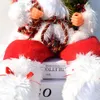 A close-up of a Santa Claus doll sitting on top of books. Náhľad obrázku produktu