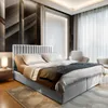 A modern bedroom with a large bed, accent wall, and chairs. Produktbild-Vorschau