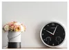 A wall clock with two gauges sits on a shelf next to a vase of roses. Podgląd zdjęcia produktu