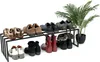 A black metal shoe rack holding several pairs of shoes and a potted plant. Podgląd zdjęcia produktu