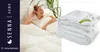 A woman is lying on a bed with a duvet, and a folded duvet is shown next to it. Podgląd zdjęcia produktu
