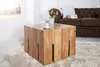 A wooden coffee table in a living room setting with a sofa in the background. Produktbild-Vorschau