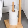 A toilet paper holder with two rolls of toilet paper on it, placed on a bathroom floor next to a toilet. Náhled obrázku produktu