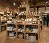 A retail store display featuring wooden crates filled with home goods and decor. Anteprima dell’immagine prodotto