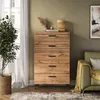 A chest of drawers in a living room setting, next to a sofa and a plant. Náhled obrázku produktu