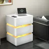 A white nightstand with illuminated drawers is placed next to a dark sofa in a room. Náhľad obrázku produktu