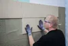 A person tiling a wall. Produktbild-Vorschau