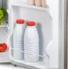 Interior of a refrigerator with two white bottles with red caps on a shelf. Voir les images du produit