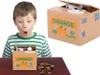 A boy is looking with surprise at a coin bank that is eating coins. There are coins scattered on the table. Náhľad obrázku produktu