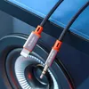 A close-up shot of a Mcdodo adapter cable with a Lightning connector on one end and a 3.5mm jack on the other, resting on a speaker. Anteprima dell’immagine prodotto