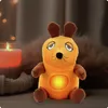 A plush toy mouse with a glowing belly sits on a surface next to a lit candle and fuzzy material. Anteprima dell’immagine prodotto