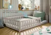 A child's bed with protective rails, set up in a bedroom with toys on the windowsill. Voir les images du produit