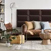 A living room scene with a leather sofa, accent chair, floor lamp, and coffee table, featuring decorative wall panels. Anteprima dell’immagine prodotto