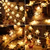 A collage of four images showing snowflake-shaped LED string lights, some with Christmas-themed decorations in the background. Produktbild-Vorschau