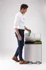 A man is shown discarding an item into a dual-compartment trash can. Podgląd zdjęcia produktu
