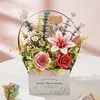 A 3D wooden flower basket model with various flowers and decorative elements, placed on a white surface with a pink background. Podgląd zdjęcia produktu