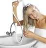 A woman is washing her hair in a sink using a handheld shower attachment. Produktbild-Vorschau